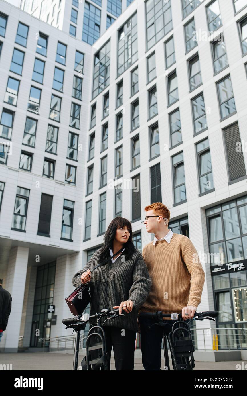 Upward shot of a young couple standing close in front of high storey building Stock Photo