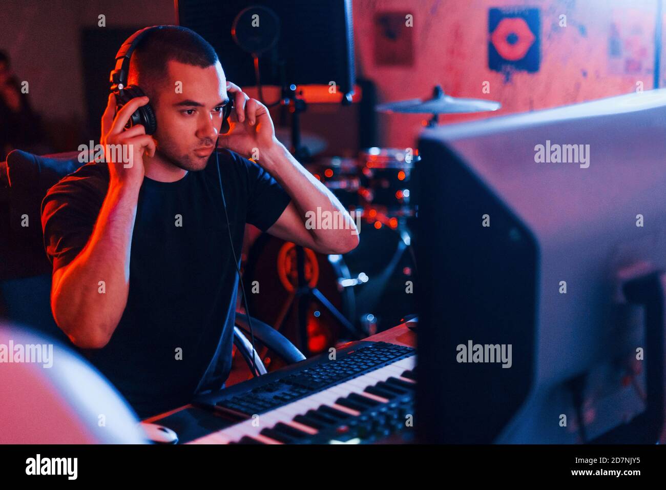 Sound engineer in headphones working and mixing music indoors in the ...