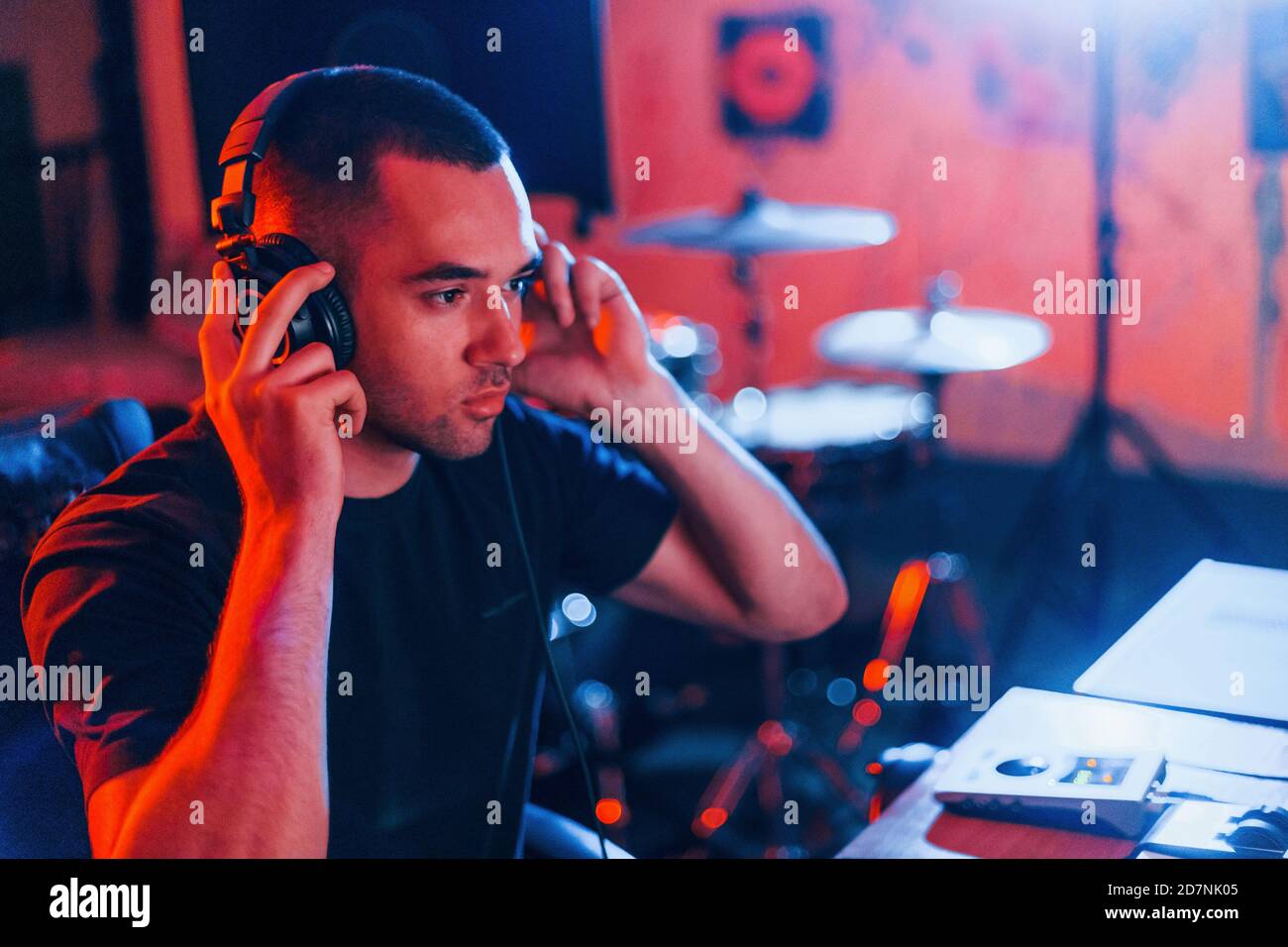 Sound engineer in headphones working and mixing music indoors in the ...