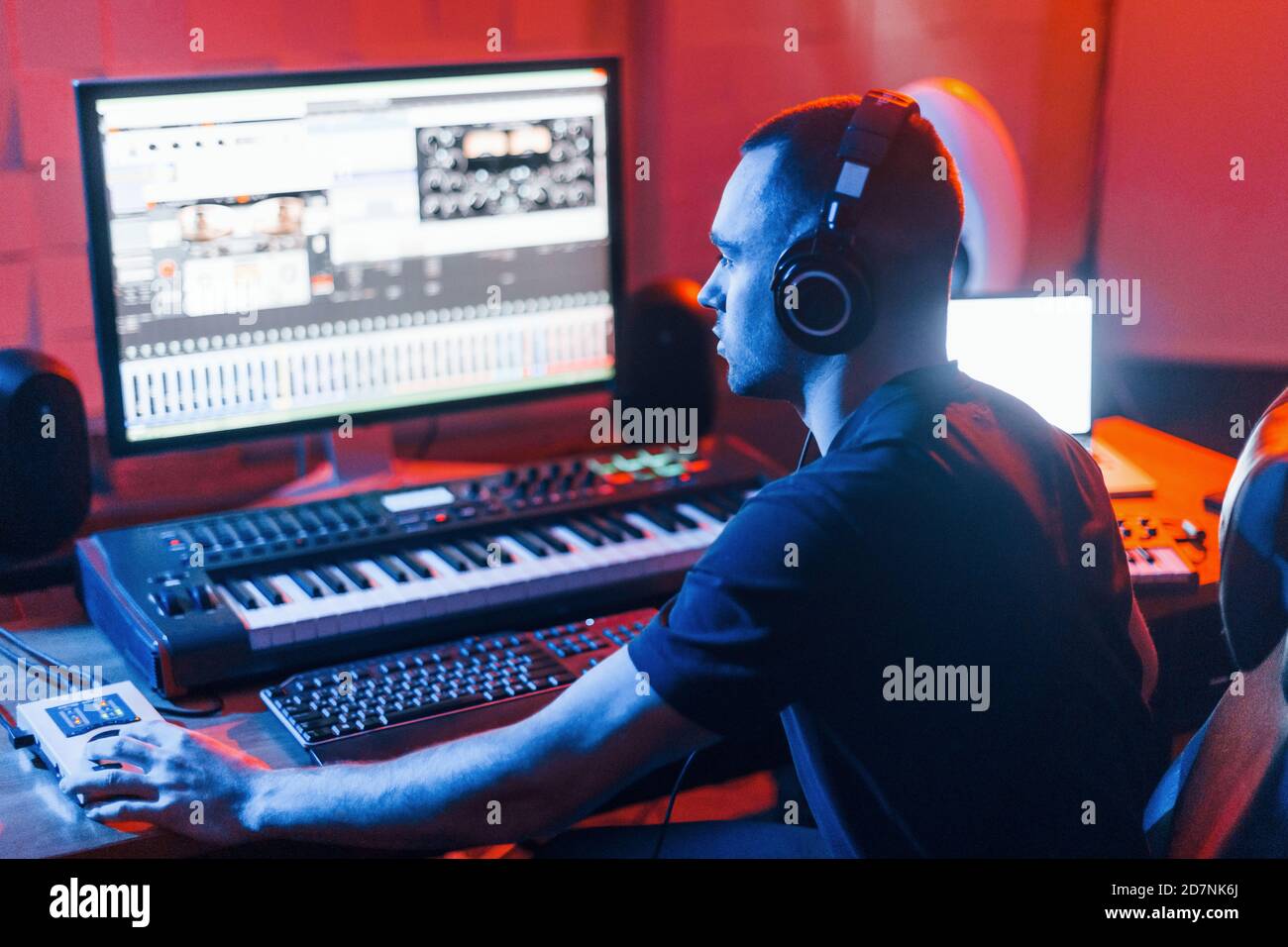 Sound engineer in headphones working and mixing music indoors in the ...