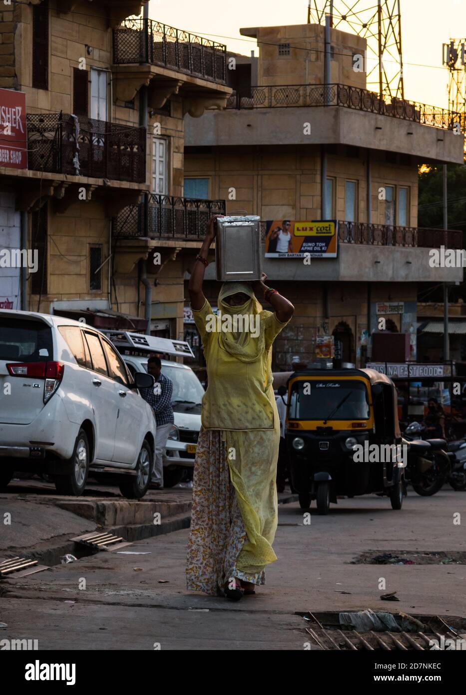 Jaisalmer, Rajasthan / India - september 24 2020 : Woman carrying container of wheat flour on her head taking to her house Stock Photo