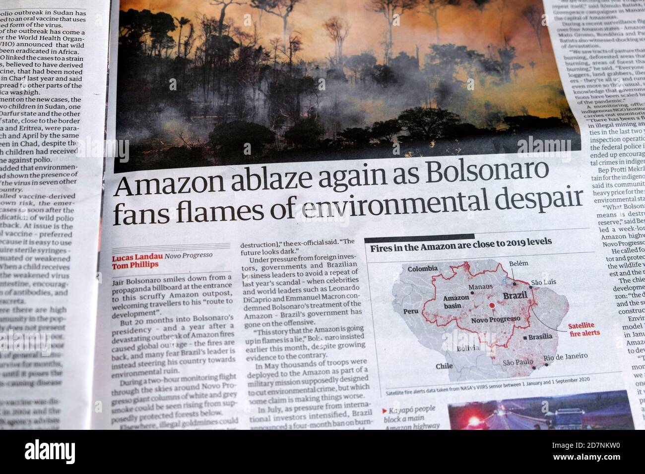 'Amazon ablaze again as Bolsonaro fans flames of environmental despair' Guardian newspaper headline inside page article London UK Stock Photo