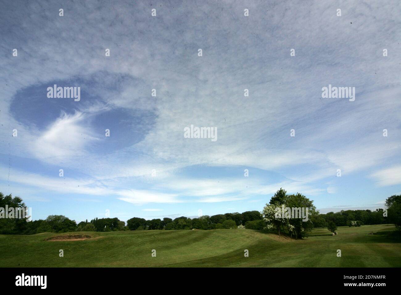 Ayr, South Ayrshire, Scotland, UK. A strange cloud formation over the golf course which makes it look like a hold has been punched in the cloud, known as Fallstreak or hole punch clouds. The clouds can form when water droplets are colder than freezing temperature but have yet to freeze. Stock Photo