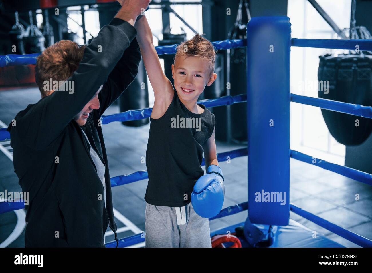 Boxing coach standing in the ring with boy and celebrating victory together Stock Photo Alamy