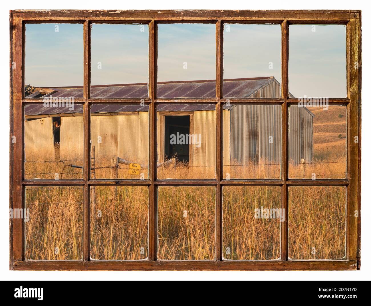 old metal barn in Nebraska Sandhills as seen from a vintage sash window Stock Photo