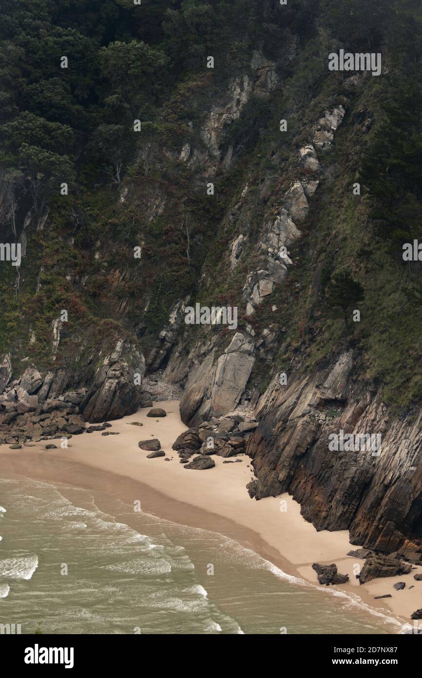 Stunning landscape of a cliff ending on a beach Stock Photo