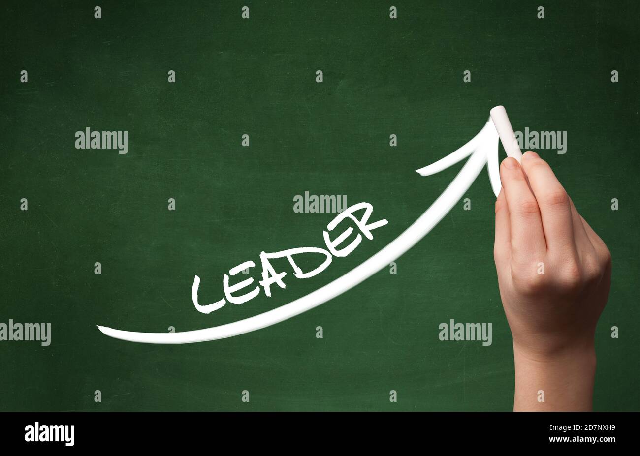 Hand drawing LEADER inscription with white chalk on blackboard ...