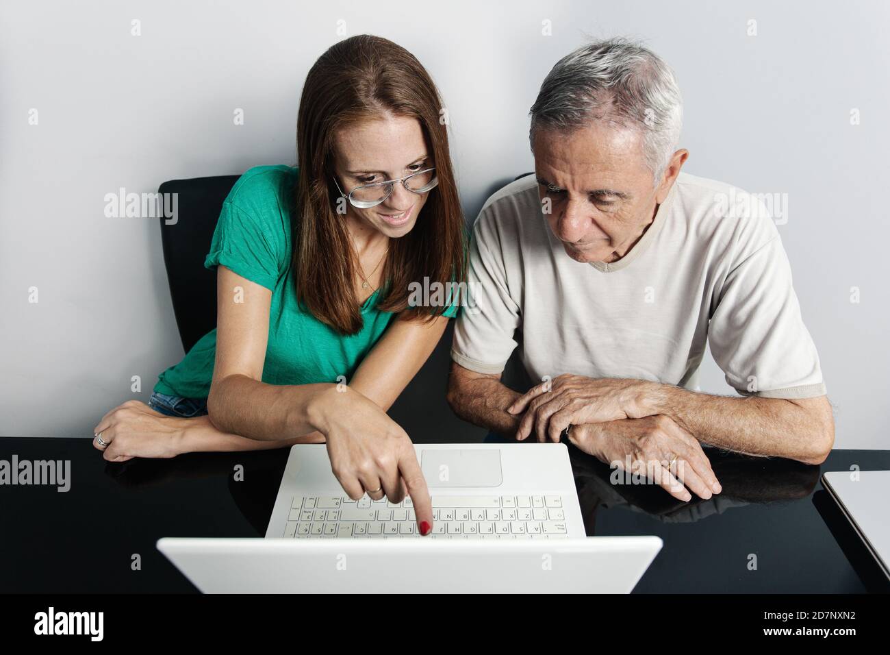 Woman helping father with laptop Stock Photo