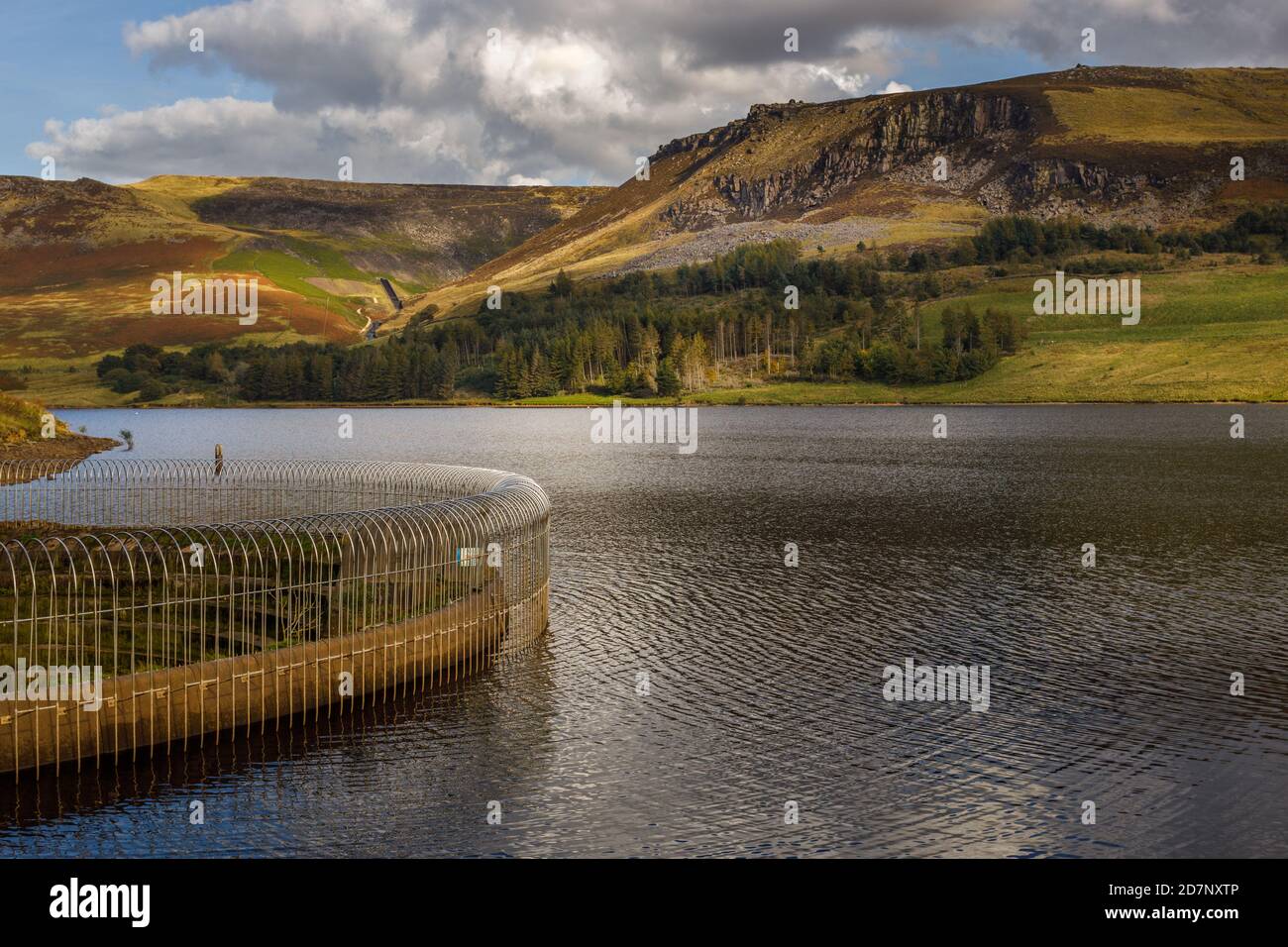 Overflow, Dovestone reservoir, Greenfield Saddleworth on a clear sunny day with hillls, beautiful reflections and cloud patterns on the hillside. Stock Photo