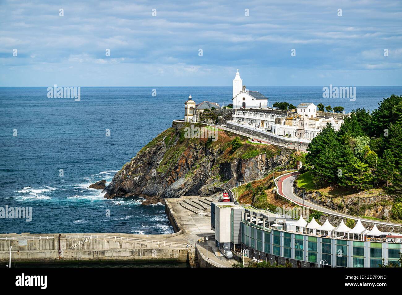 Picturesque chapel with the cemetery and a lighthouse overlooking Cantabrian sea in the village of Luarca, Asturias, Spain. Stock Photo