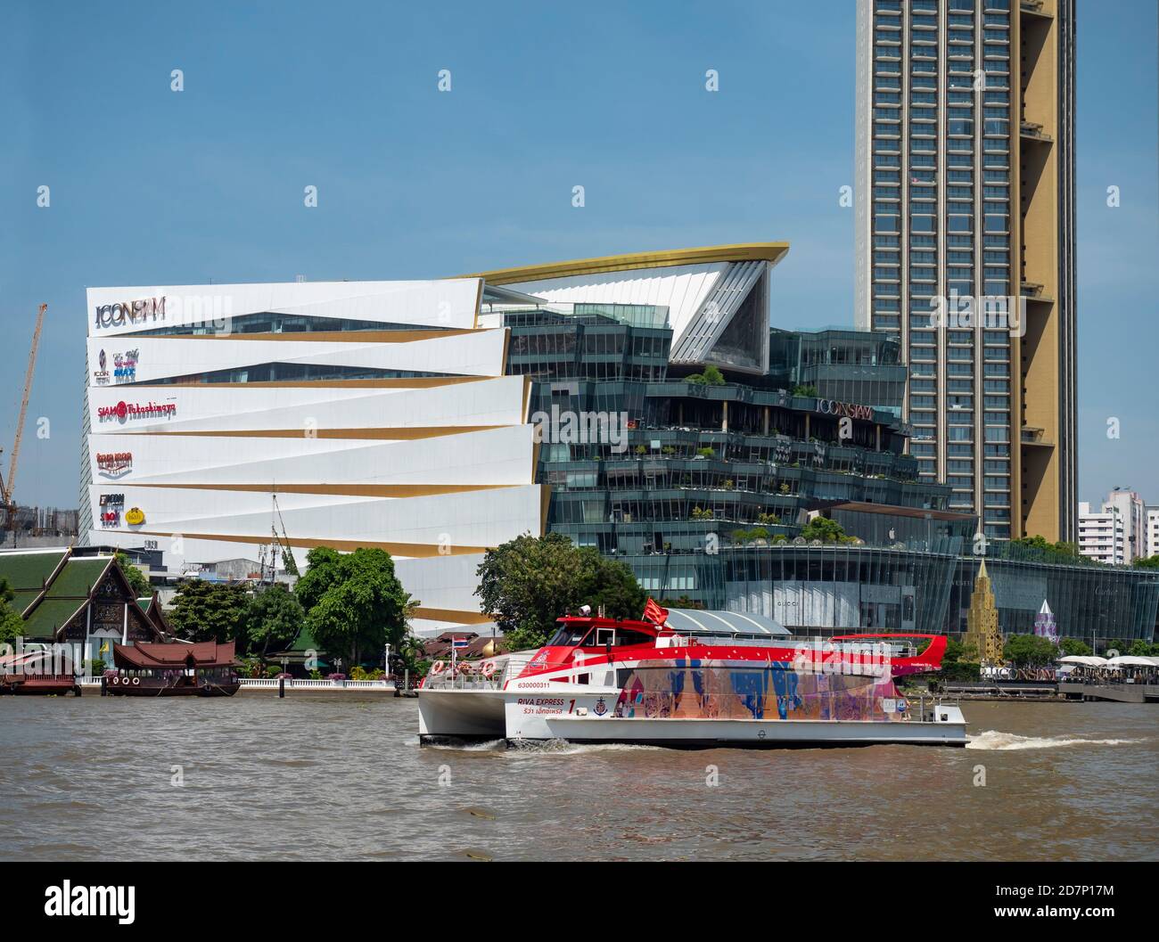 Chao Praya River in Bangkok with a cross river shuttle catamaran ferry in the foreground and Icon Siam shopping mall and residence towers across the r Stock Photo