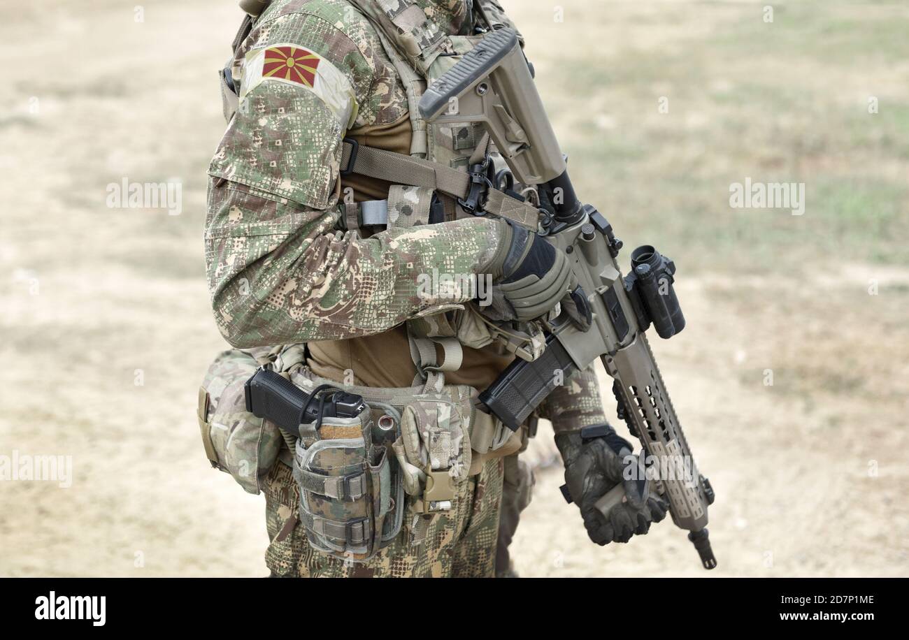 Soldier with assault rifle and flag of North Macedonia on military