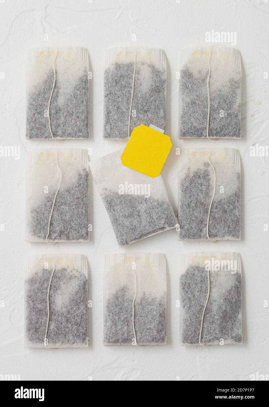 Black tea in teabags with yellow label on white background. Top view Stock Photo