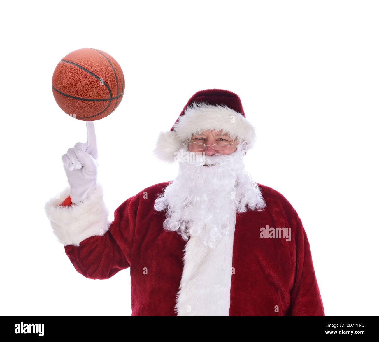 Santa Claus with his index finger pointing up with a basketball balanced on the tip, isolated on white. Stock Photo