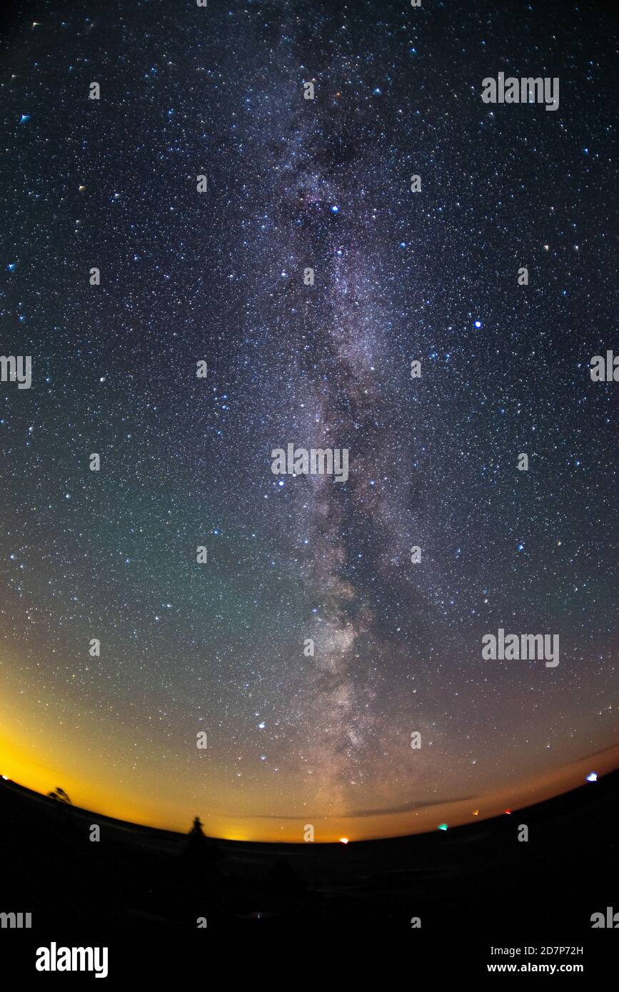 Colourful image of stars and Milky Way right after the sunset featuring distorted horizon Stock Photo