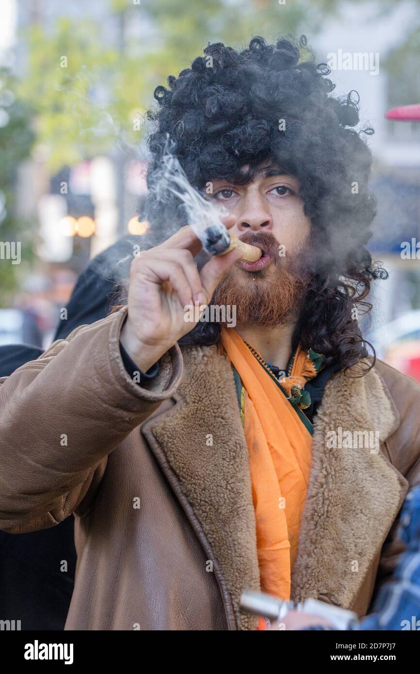 Toronto, Canada. 17th Oct, 2018. A man wearing a black curly wig smoking a big joint during the cannabis legalization celebration day at Trinity Bellwoods Park. Credit: Shawn Goldberg/SOPA Images/ZUMA Wire/Alamy Live News Stock Photo
