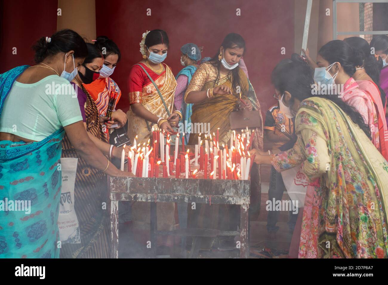 Hindu devotees wearing masks light Diyas (Soil made Lamp) during the Sandhi  Puja Ritual of Durga Ashtami.Sandhi Puja is treated as the junction time  between the Eighth & Ninth day of Durga