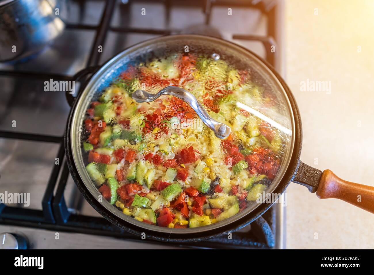 a big pilaf pan bowl with mix of vegetables , cooking on the kitchen. rice with red beans and vegetables in a frying pan Stock Photo