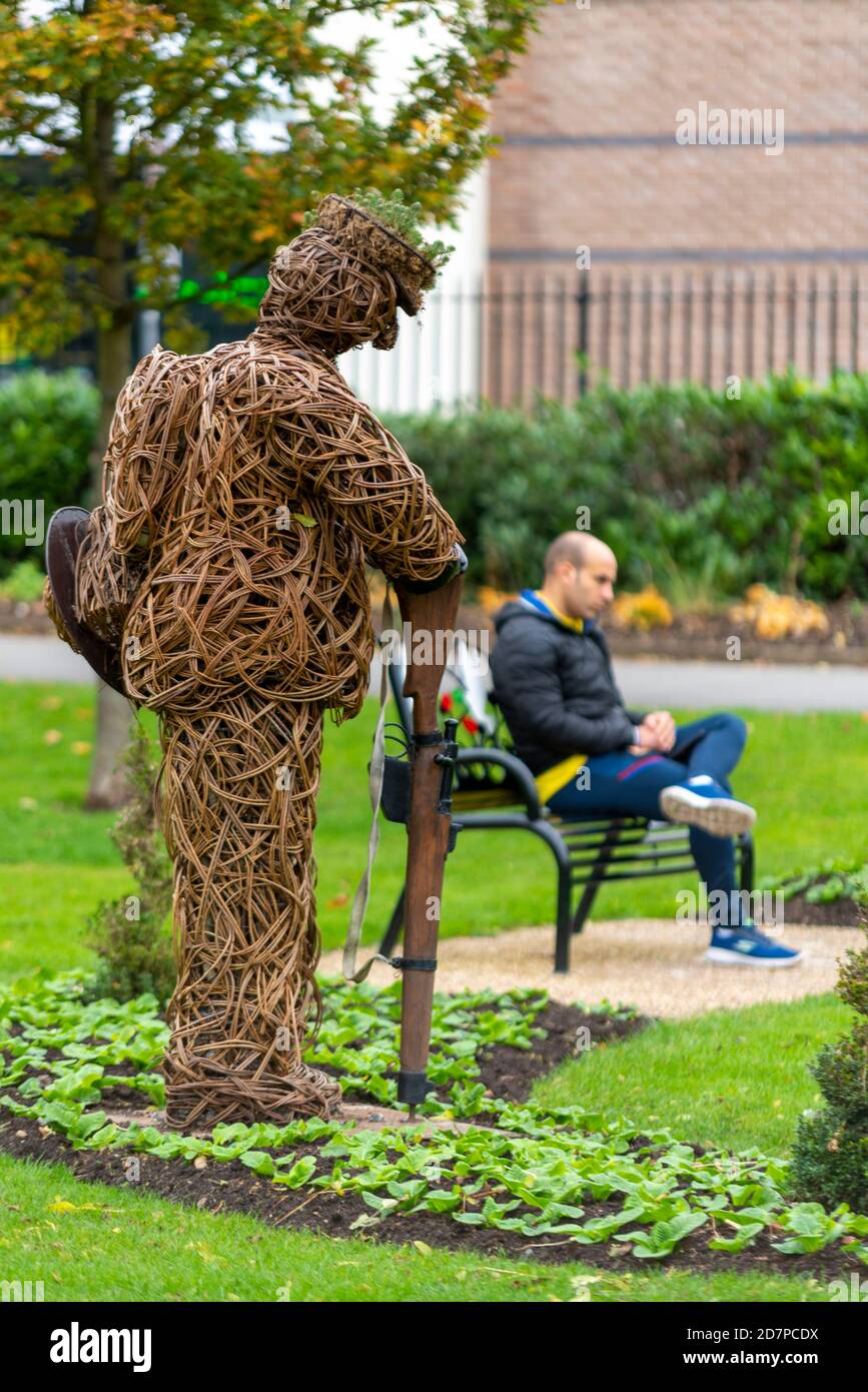 VE Day 75th anniversary soldier memorial in Central Park, Chelmsford, Essex, UK, with a white Caucasian male sitting, relaxing. Willow art Stock Photo