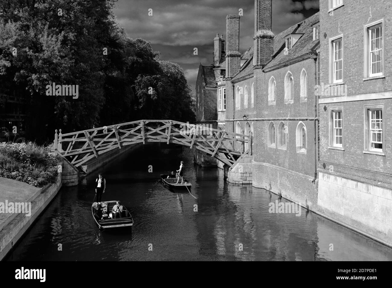 People Punting on the river Cam under the Mathematical Bridge and Queen's College, Cambridge City, England Stock Photo