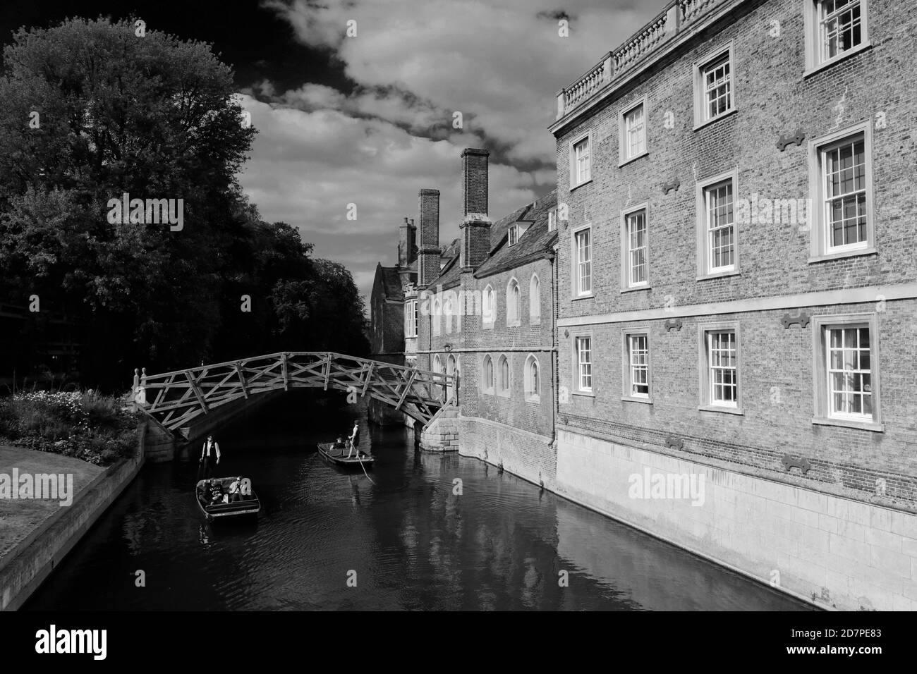 People Punting on the river Cam under the Mathematical Bridge and Queen's College, Cambridge City, England Stock Photo