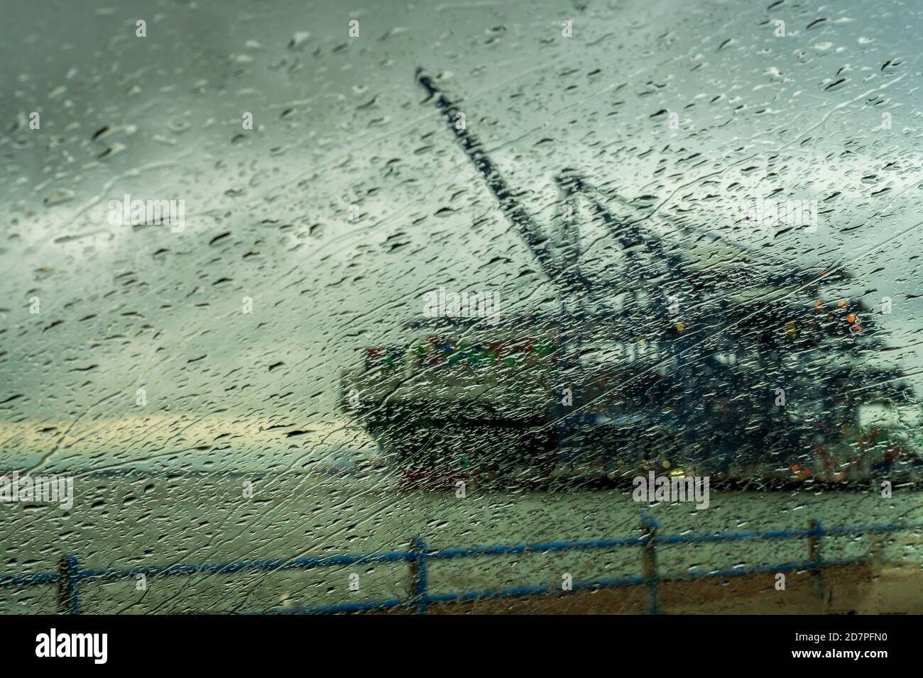 Any Port in a storm - A container ship is unloaded during a rainstorm at the Port of Felixstowe, the UK's largest container port. Stormy Trade Talks. Stock Photo