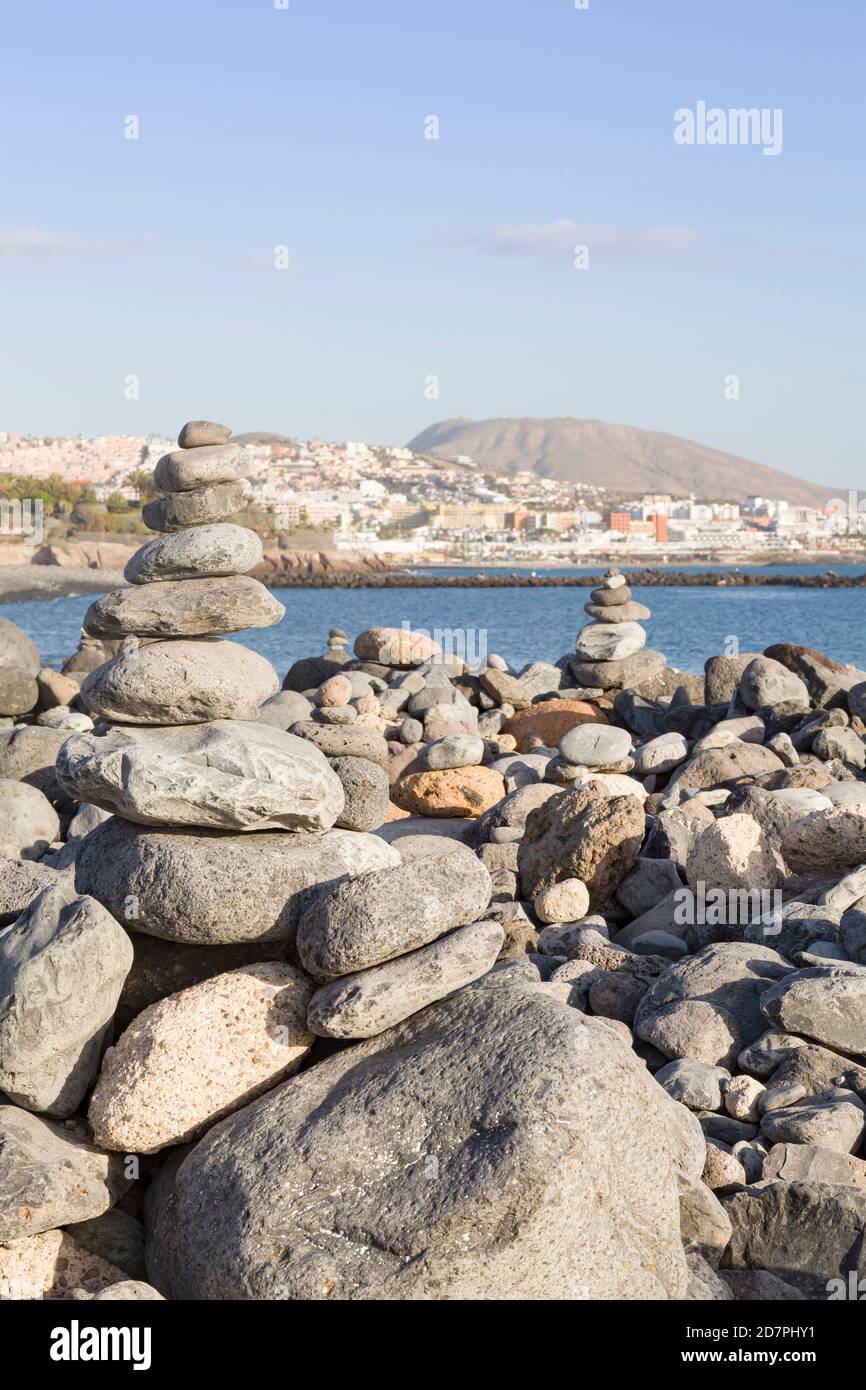 Closeup of piles of stones balanced, stacked in a pyramid on a beach in Costa Adeje, Tenerife, Canary Islands Stock Photo