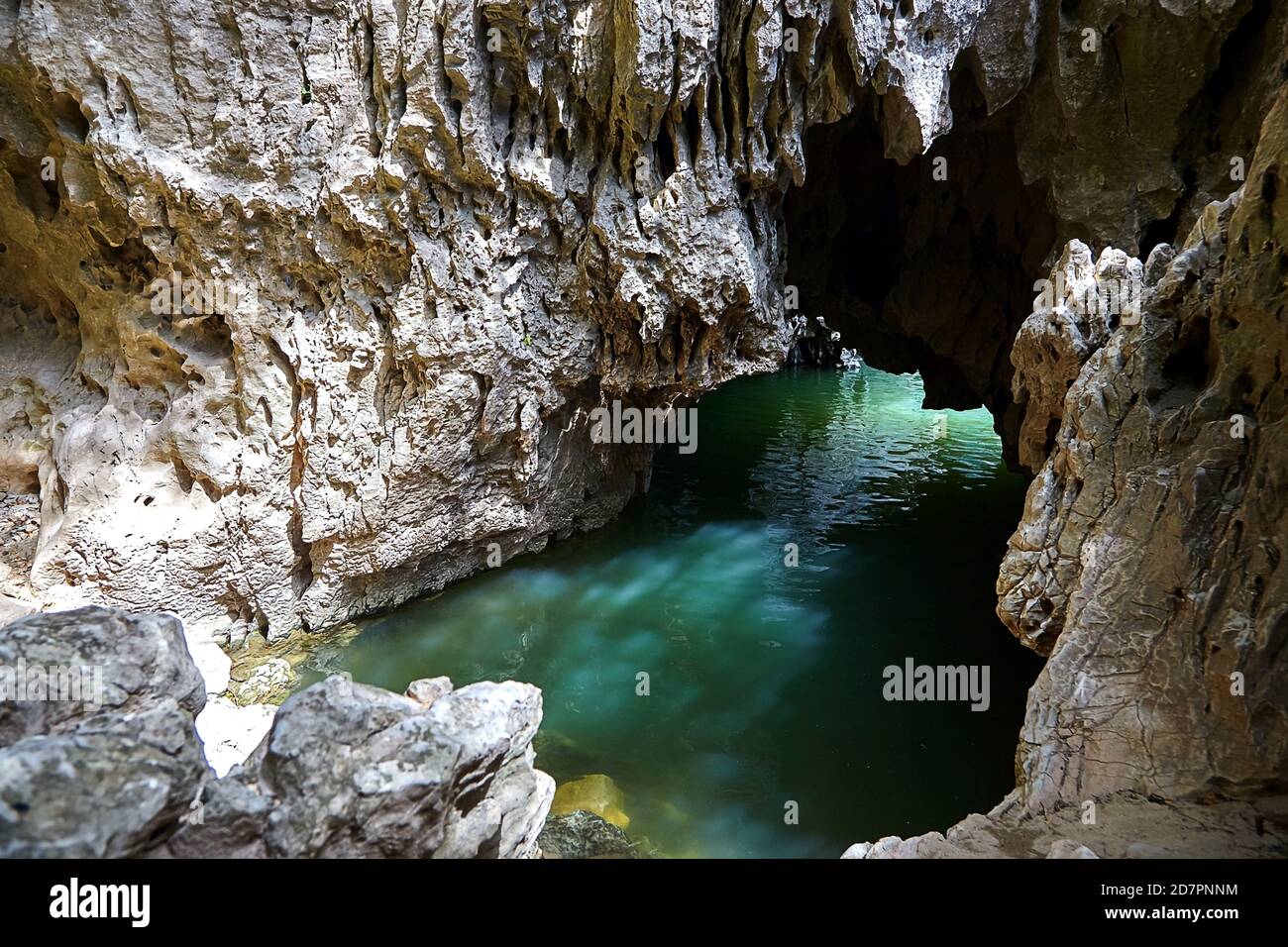 Cave in rock filled with river water. Glare on the stone surface of the ...
