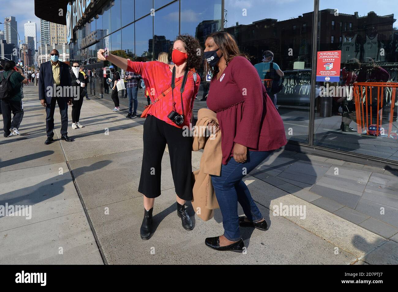 New York City, USA. 24th Oct, 2020. Attorney General of New York Letitia James (r) takes a selfie with a voter waiting in line outside the Barclays Center on the first day of early voting for the 2020 Presidential elections, in the New York City borough of Brooklyn, NY, October 24, 2020. In a deal reached with the NBA, sports arenas such as the Barclays Center will be used as polling sites, one of 88 early voting ballot casting sites, this the first time in history New York participates in early voting. (Anthony Behar/Sipa USA) Credit: Sipa USA/Alamy Live News Stock Photo