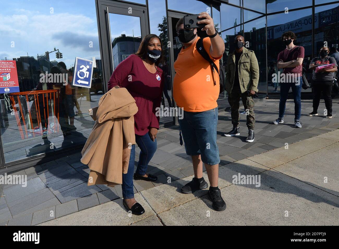 New York City, USA. 24th Oct, 2020. Attorney General of New York Letitia James (l) takes a selfie with a voter waiting in line outside the Barclays Center on the first day of early voting for the 2020 Presidential elections, in the New York City borough of Brooklyn, NY, October 24, 2020. In a deal reached with the NBA, sports arenas such as the Barclays Center will be used as polling sites, one of 88 early voting ballot casting sites, this the first time in history New York participates in early voting. (Anthony Behar/Sipa USA) Credit: Sipa USA/Alamy Live News Stock Photo