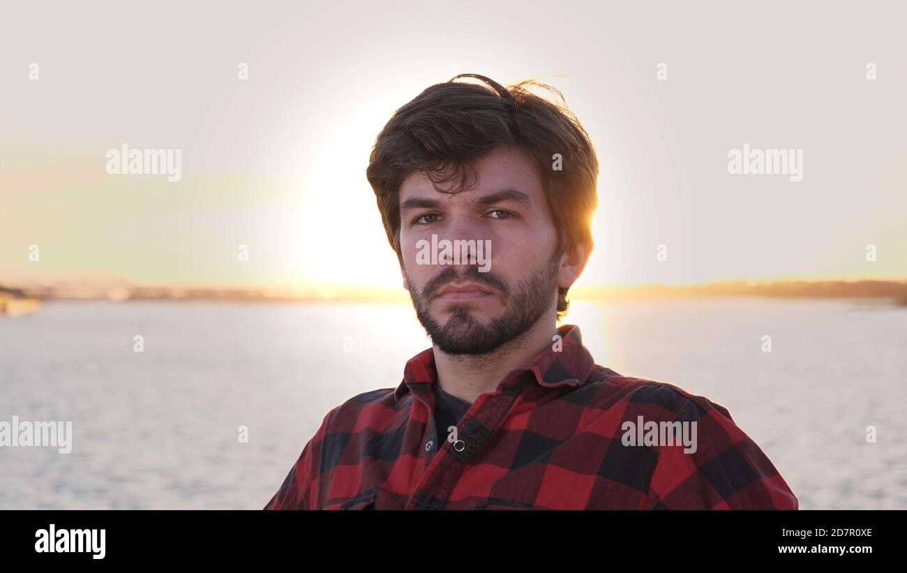 Happy man smiling to camera outdoors during sunset Stock Photo - Alamy