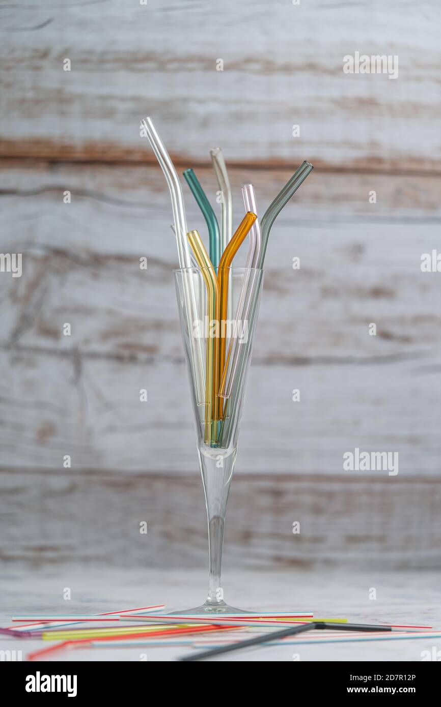 Glass straws replacing plastic straws in glass with wood background
