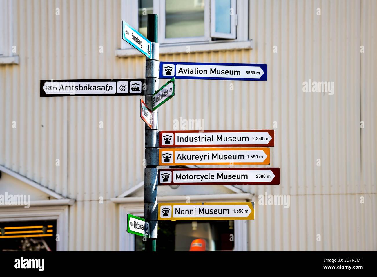 Akureyri, Iceland - June 17, 2018: Street road in town village city with closeup of intersection directional sign for famous museums and stores shops Stock Photo