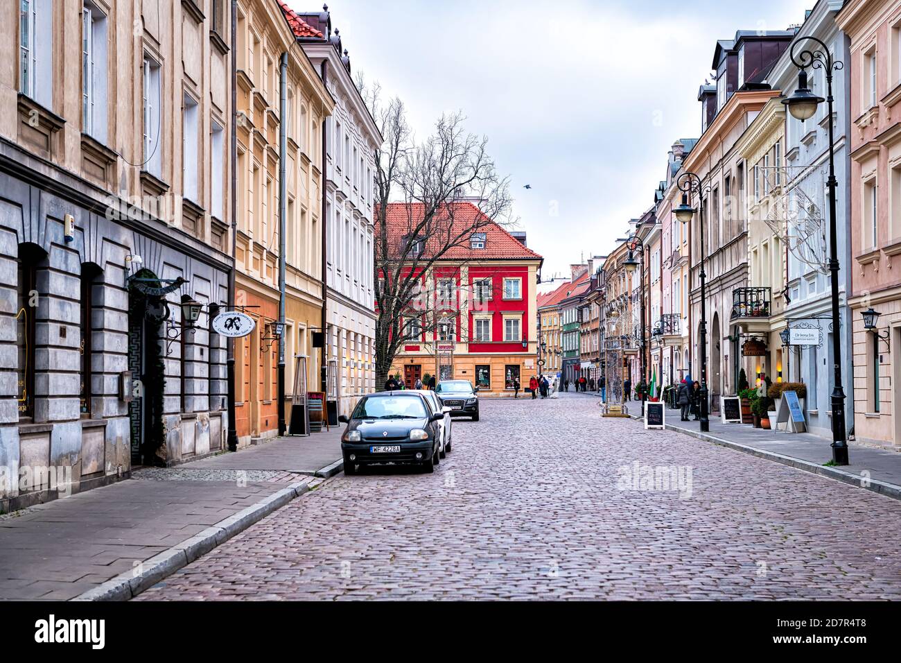 Warsaw, Poland - December 21, 2019: Cobblestone Freta street in old town by Warszawa market square with people walking by Italian restaurant, stores a Stock Photo