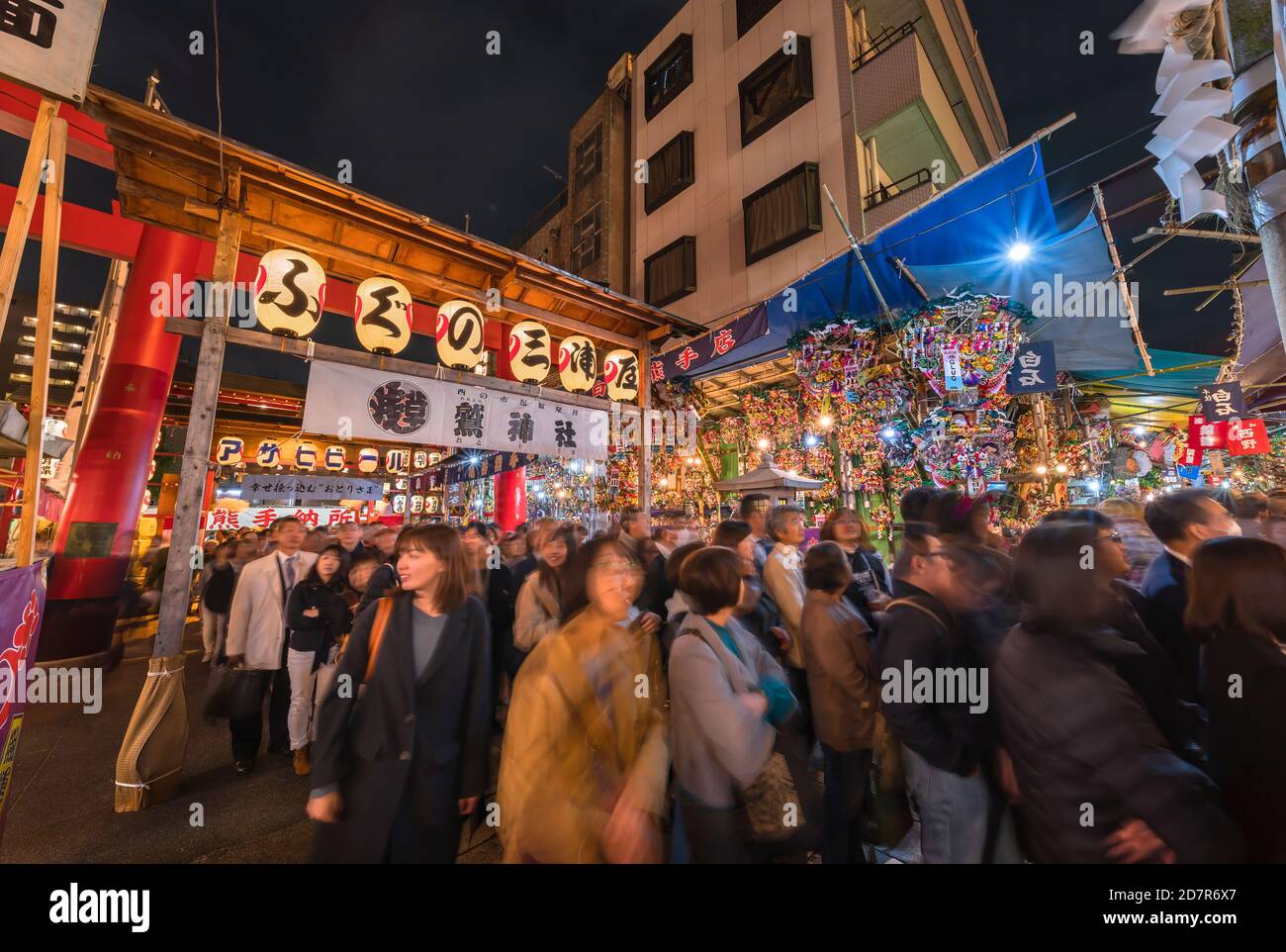 asakusa, japan - november 08 2019: Crowd passing through a gate of Tori-no-Ichi Fair decorated with luminous lanterns in Ootori shrine where traders b Stock Photo