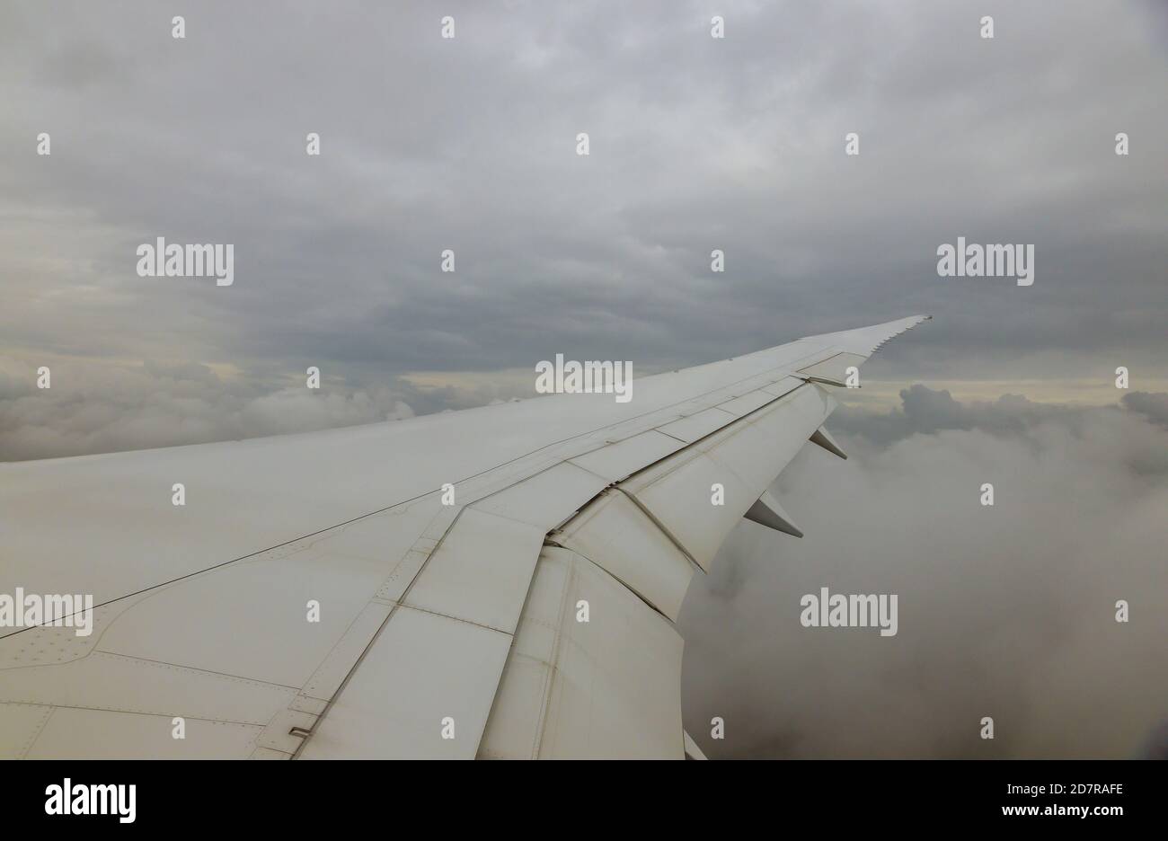 Airplane wing of airplane flying above the clouds in the sky view out ...