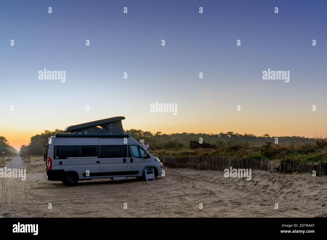A camper van parked at an idyllic beach access at sunrise Stock Photo ...
