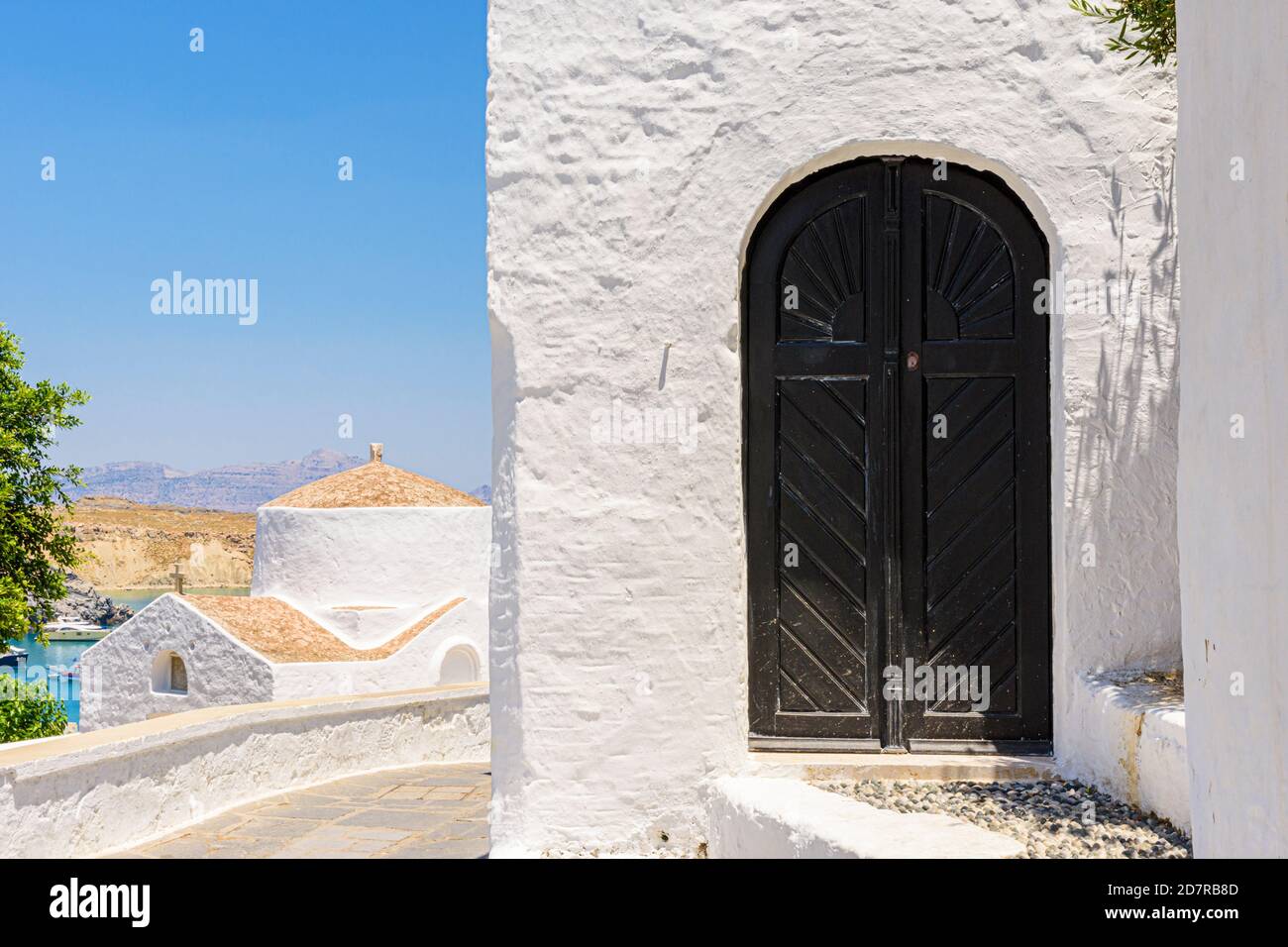 Wooden door and Chapel of Saint George Pahimahiotis in old Lindos, Rhodes, Greece Stock Photo