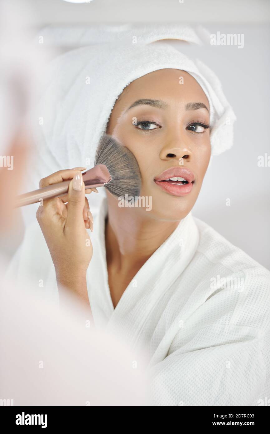 Woman applying make-up Stock Photo