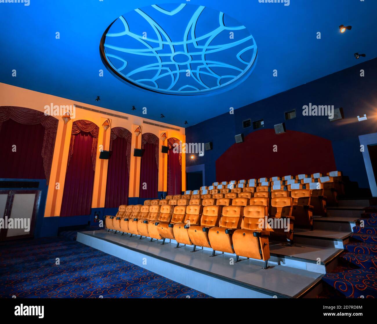 Large cinema theater interior with seat rows for audience to sit in movie theater premiere by cinematograph projector. The cinema theater is decorated Stock Photo