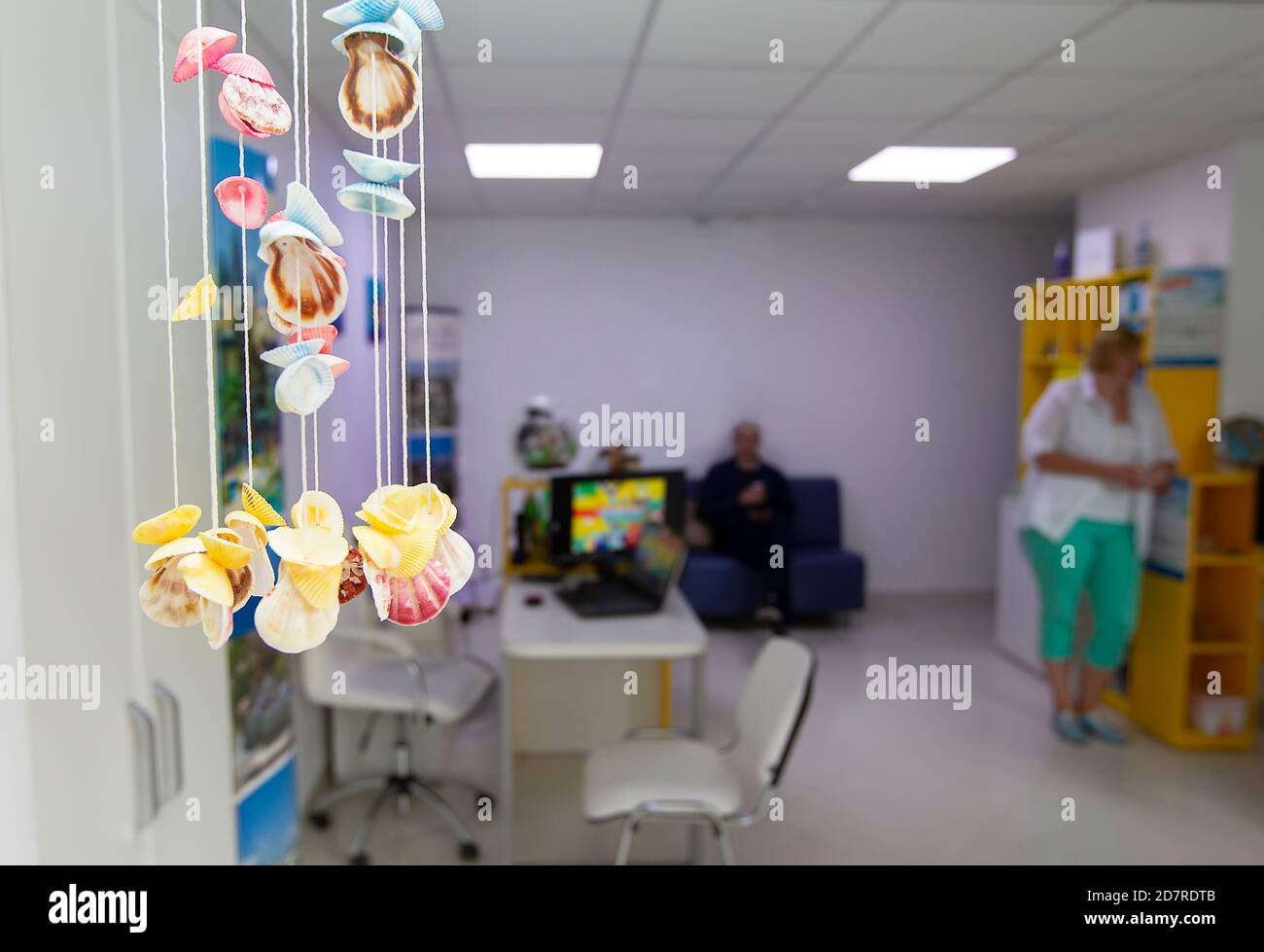 Multicolored seashells on blurred tourist office background Stock Photo