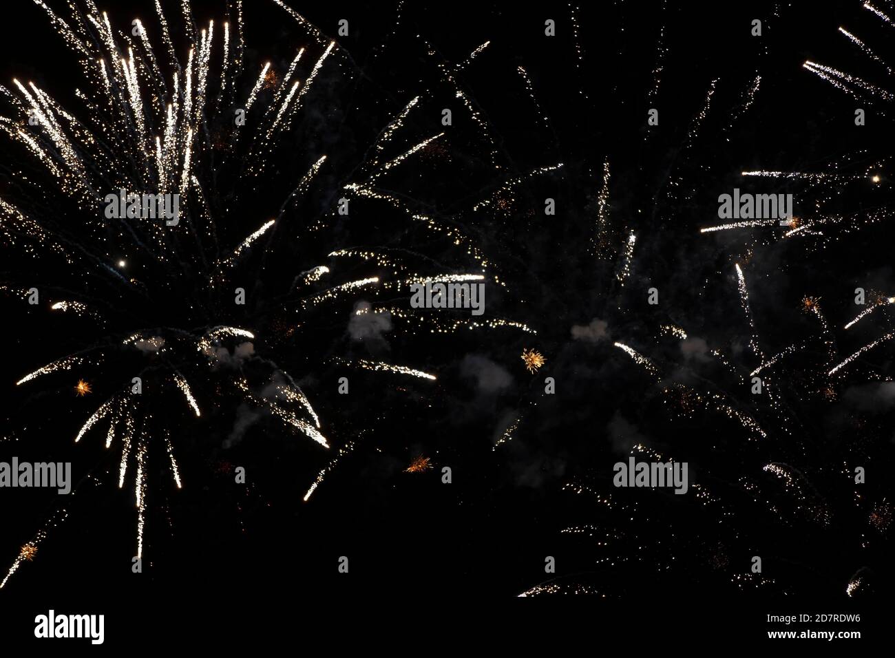 On a black background, rays and sparks of scattering fireworks. Stock Photo