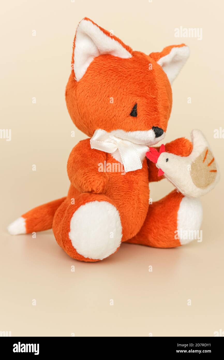 Soft toy ginger fox with chicken on a light background Stock Photo Alamy