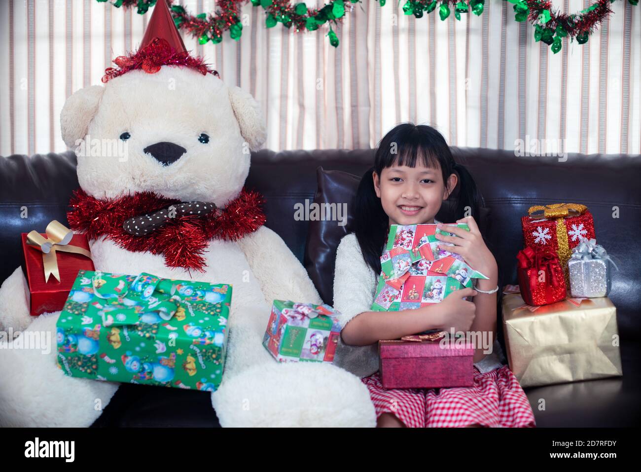 Asian little girl hugging a gift box with smile and happy in christmas ...