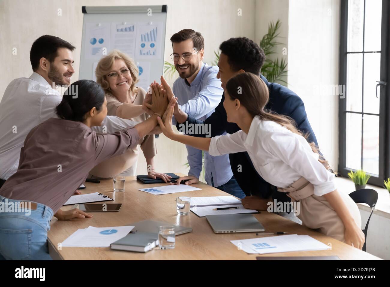 Excited diverse employees give high five at meeting Stock Photo - Alamy