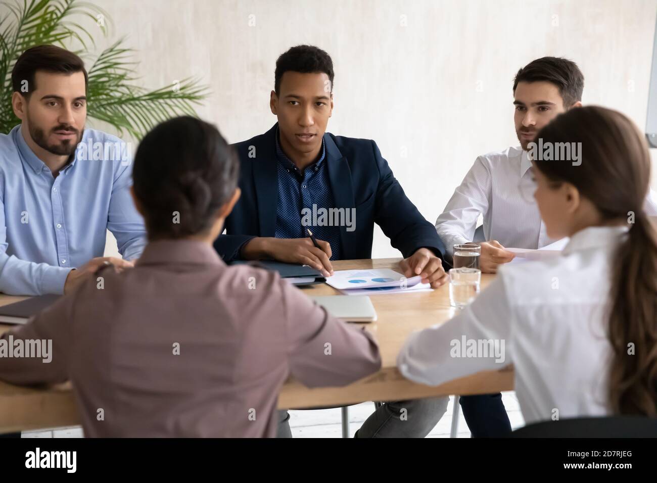 International businesspeople negotiate at meeting in office Stock Photo