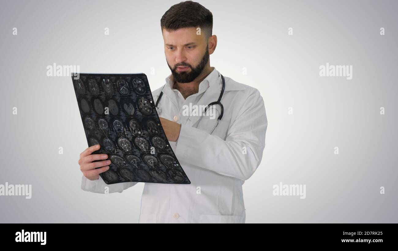 Confident doctor working with MRI scan results on gradient backg Stock Photo