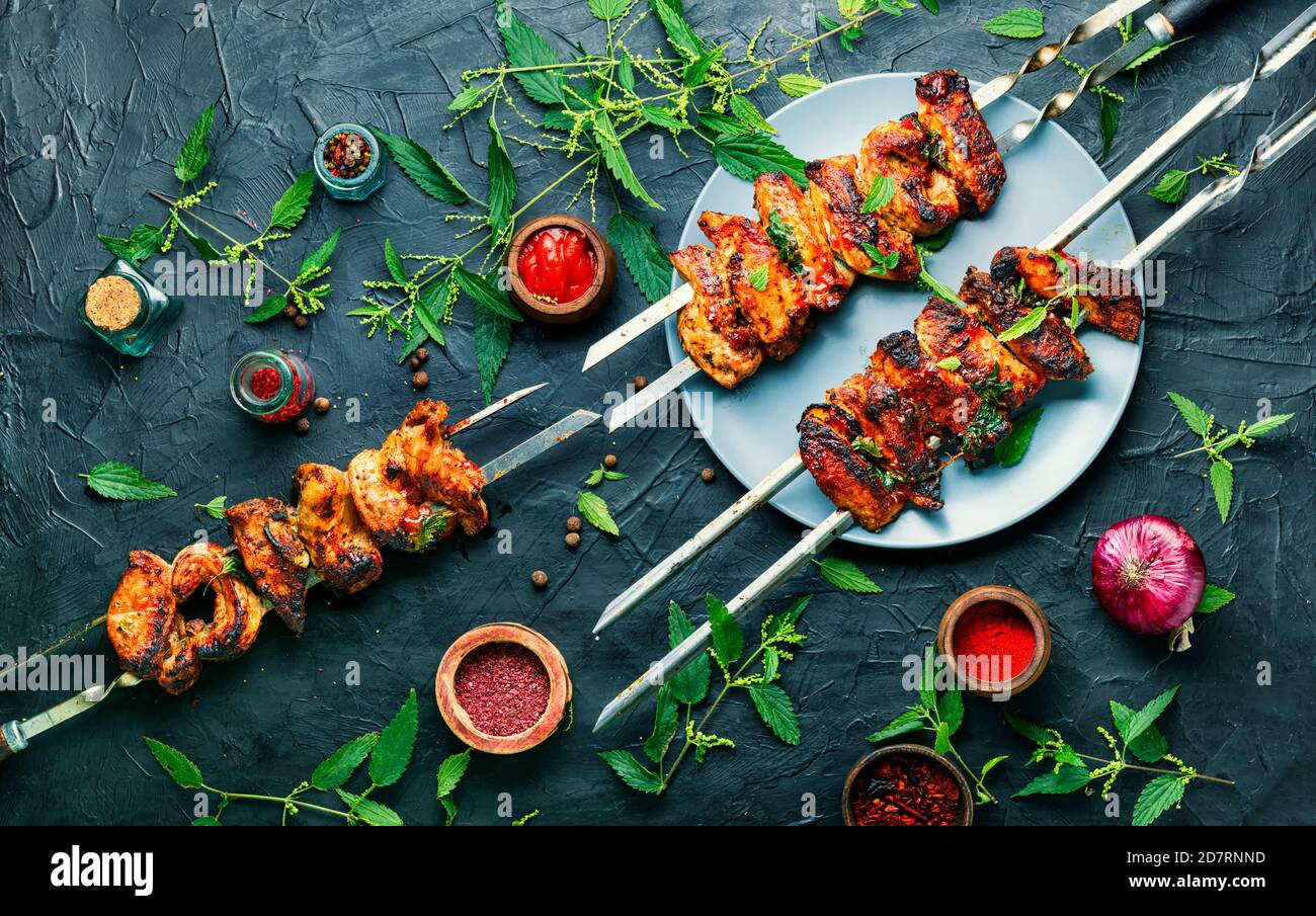 Grilled meat skewers or shish kebab pickled in nettle foliage Stock