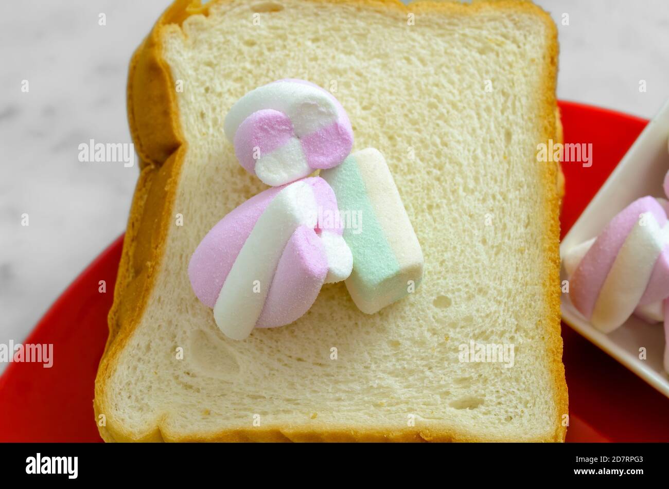 Pastel Colored Marshmallows on a slice of Bread ready to be sandwiched. Stock Photo