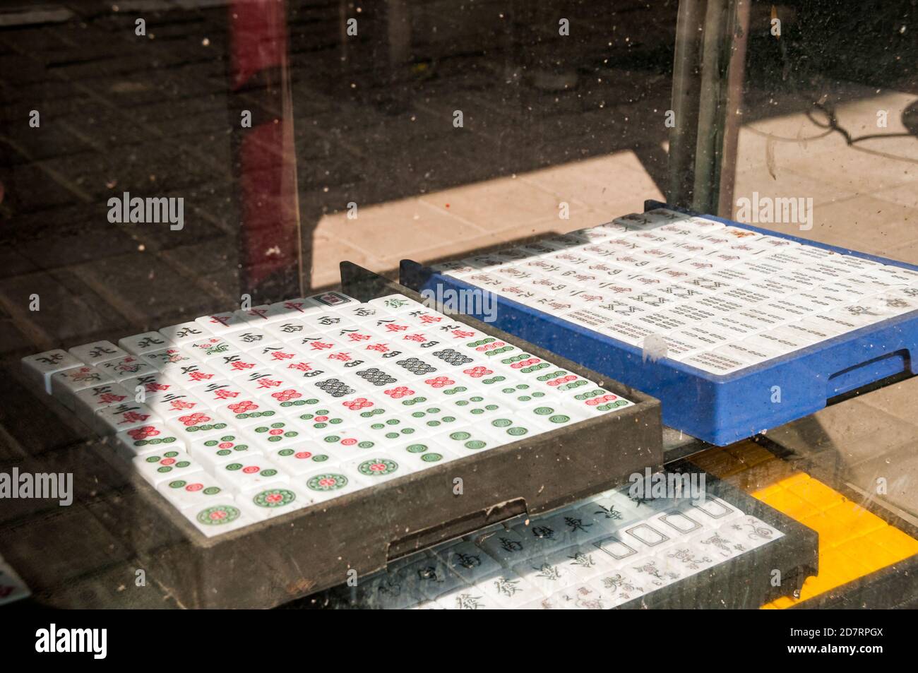 Mahjong tiles in dusty glass cabinet in a shop near Shanghai’s People’s Square. Stock Photo